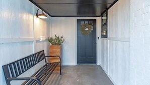 A covered porch with a bench, a potted plant, and a door with a wreath. - Clean and Updated Home in Moore with Bonus Room  (Moore)