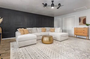 Relax in this stylish living room with a sectional sofa, coffee table, and patterned rug.