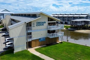 A multi-story hotel with a prominent anchor logo, a covered outdoor area, and a waterfront view.