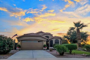 Two-story house with a garage and beautifully maintained gardens.