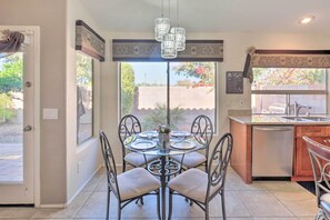 Enjoy meals in the spacious kitchen and dining area, featuring a central dining table and comfortable seating for four.