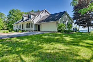 A two-story house with a garage, a front porch, and a well-maintained lawn. - Finger Lakes Vacation Rental w/ Hot Tub & Pool (Naples)
