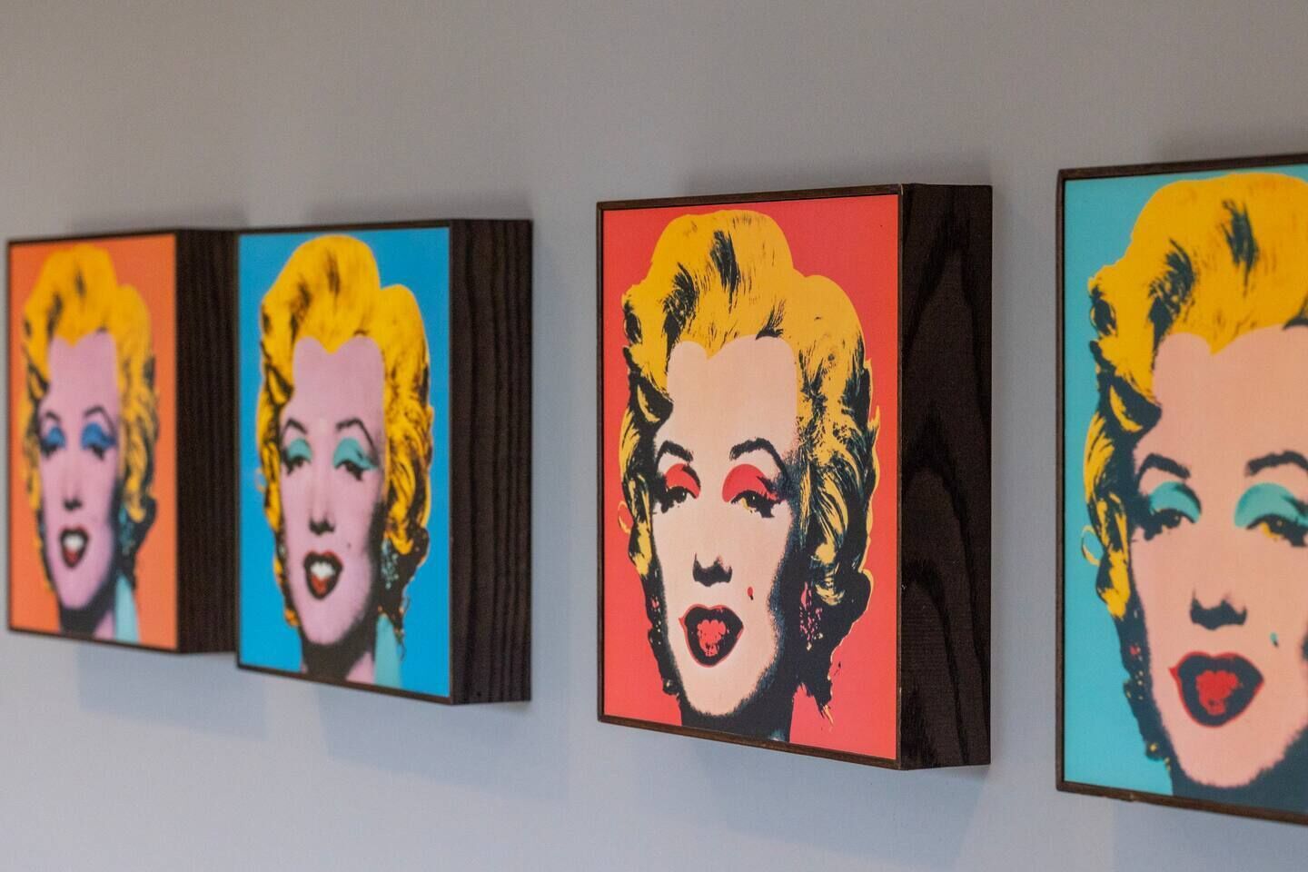 A series of three framed artworks on a wall.