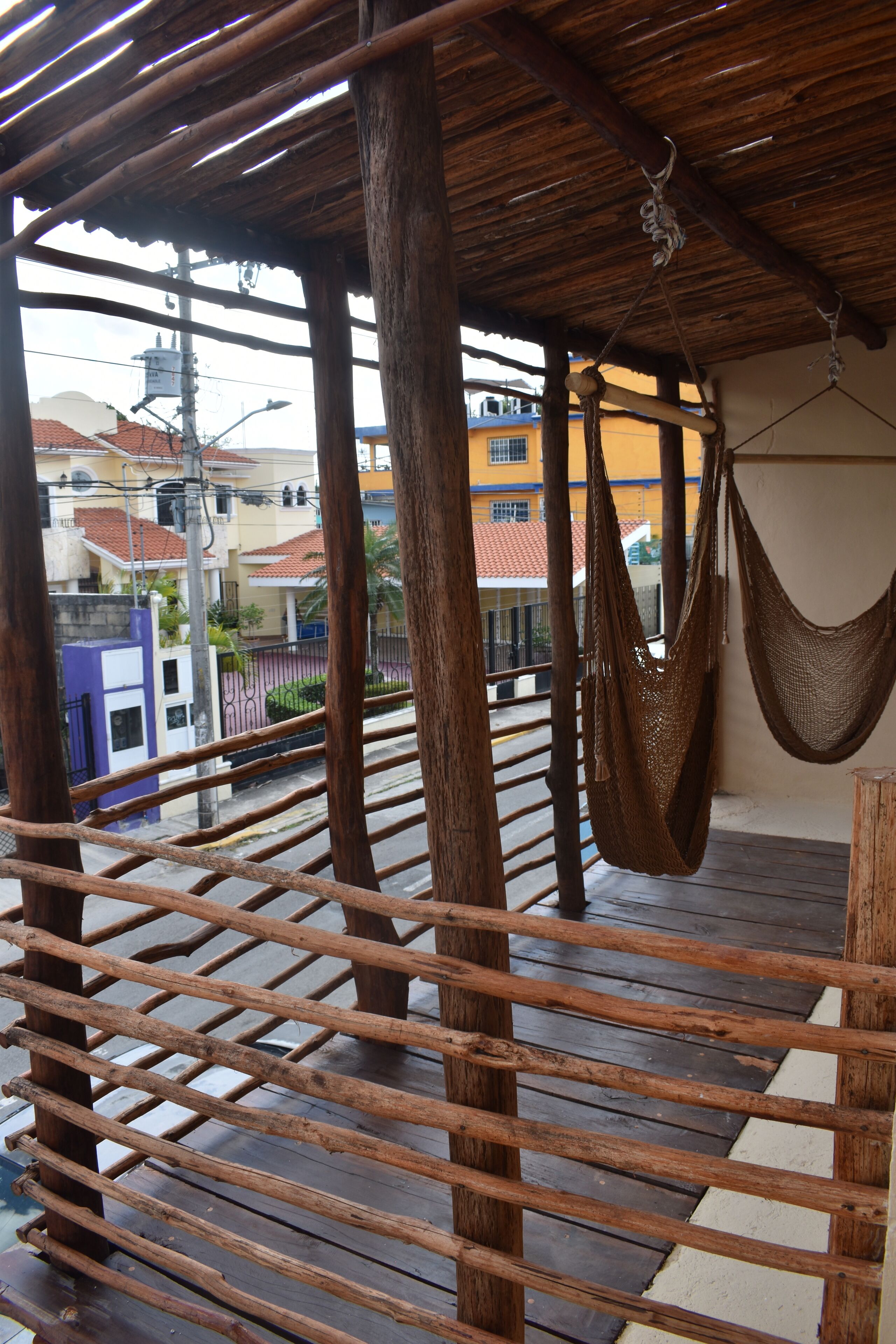Une terrasse en bois avec un hamac et une rambarde en bois.