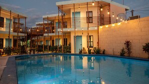 A modern hotel with a swimming pool, outdoor seating, and string lights. - Luna Azul by Uvas (Cozumel)
