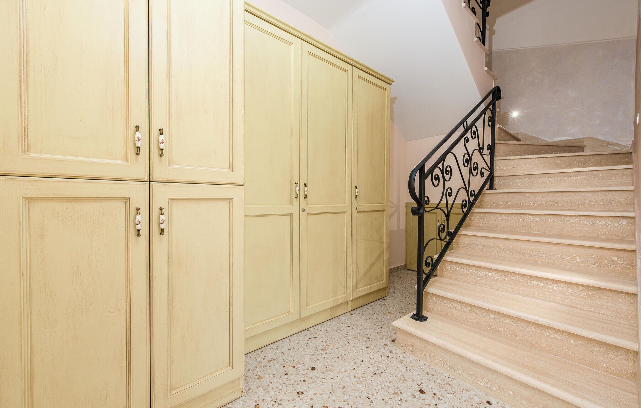 Una scala con ringhiera in metallo nero che porta a un pianerottolo.