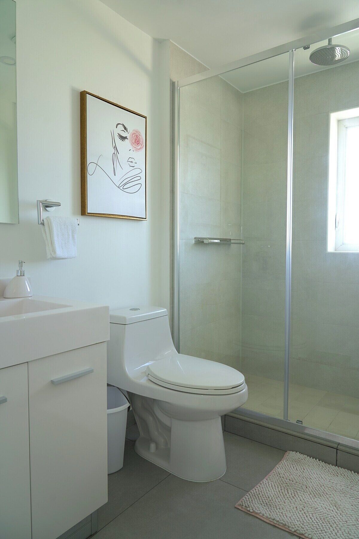 A modern bathroom with a toilet, sink, and shower.