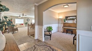 A spacious living room with a piano, a dining area, and a staircase leading to another level. - Spacious Idaho Home: Ski, Hike, & Fish! (Rexburg)
