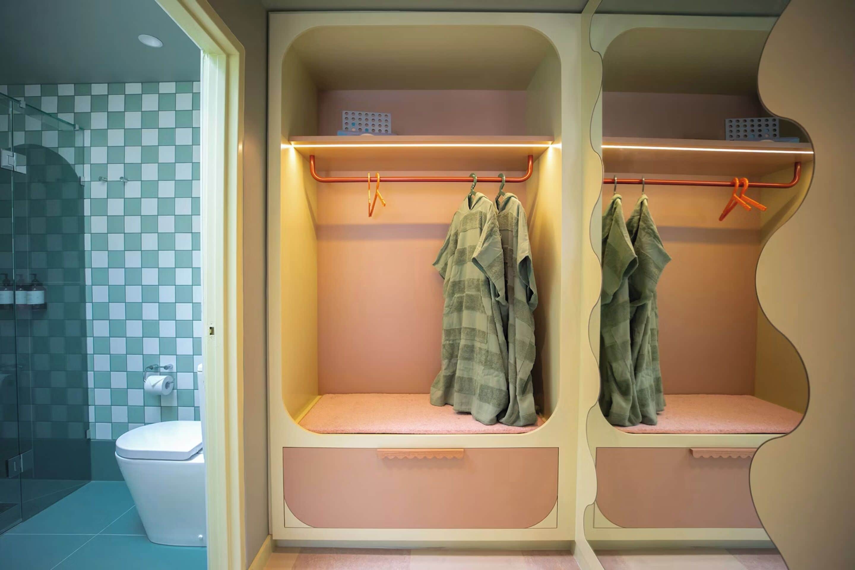 A bathroom with a checkered tile wall, a toilet, and a shower area.