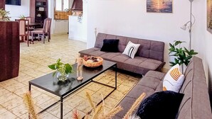 Una sala de estar con sofá, una mesa de centro y un comedor con sillas y una mesa.