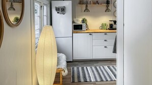 A compact kitchen with white cabinets, a microwave, a refrigerator, and a wooden countertop. - 3 bedroom beautiful home in Markaryd (Markaryd)