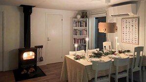 A cozy dining area with a table set for four, a bookshelf, and a fireplace. - 3 bedroom beautiful home in Markaryd (Markaryd)