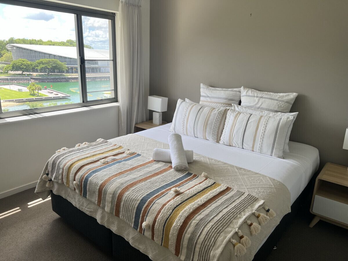 Une chambre d’hôtel avec un grand lit, une vue sur un stade et une fenêtre avec des rideaux.