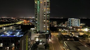 Un edificio a grattacielo con diversi piani, circondato da altri edifici e uno skyline sullo sfondo.