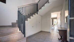 Eine Wendeltreppe mit Metallgeländer führt zu einer Plattform mit einer Tür.