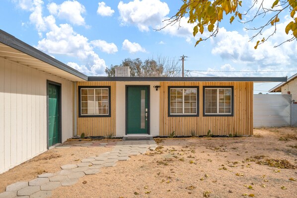 A small, single-story building with a green door, two windows, and a wooden facade. - 15% Discount! New! Cowboy Pool~Hot Tub~Stargazing (Twentynine Palms)