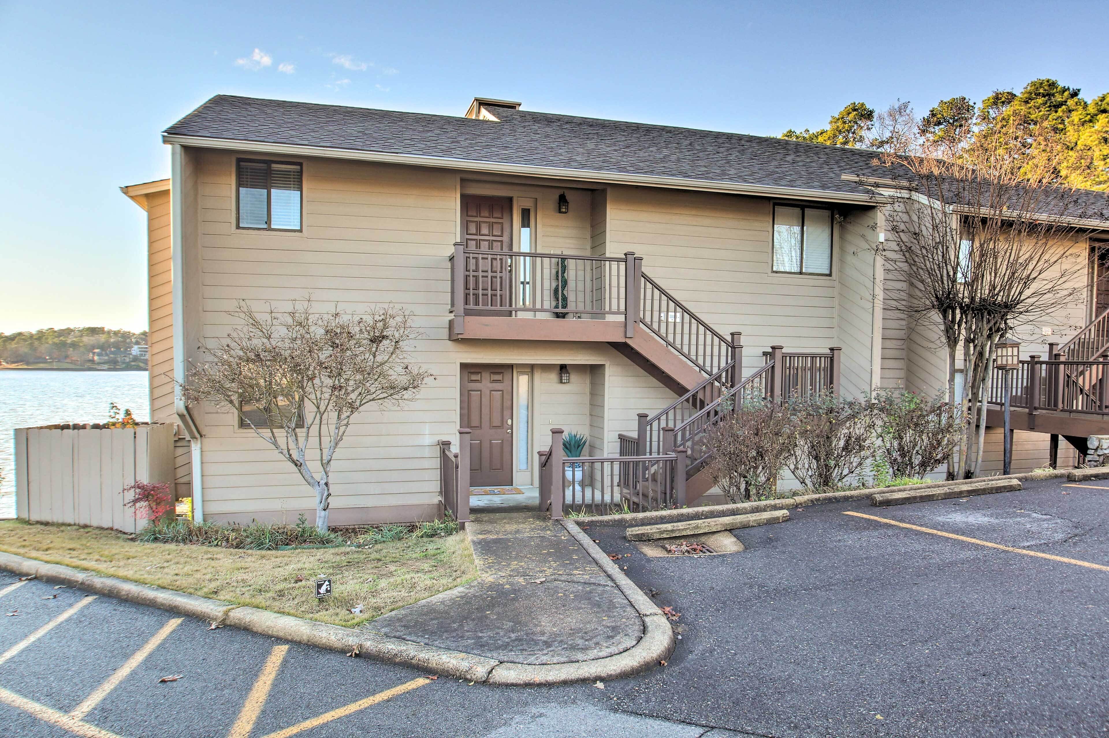 A two-story building with a balcony, a staircase, and a parking lot.