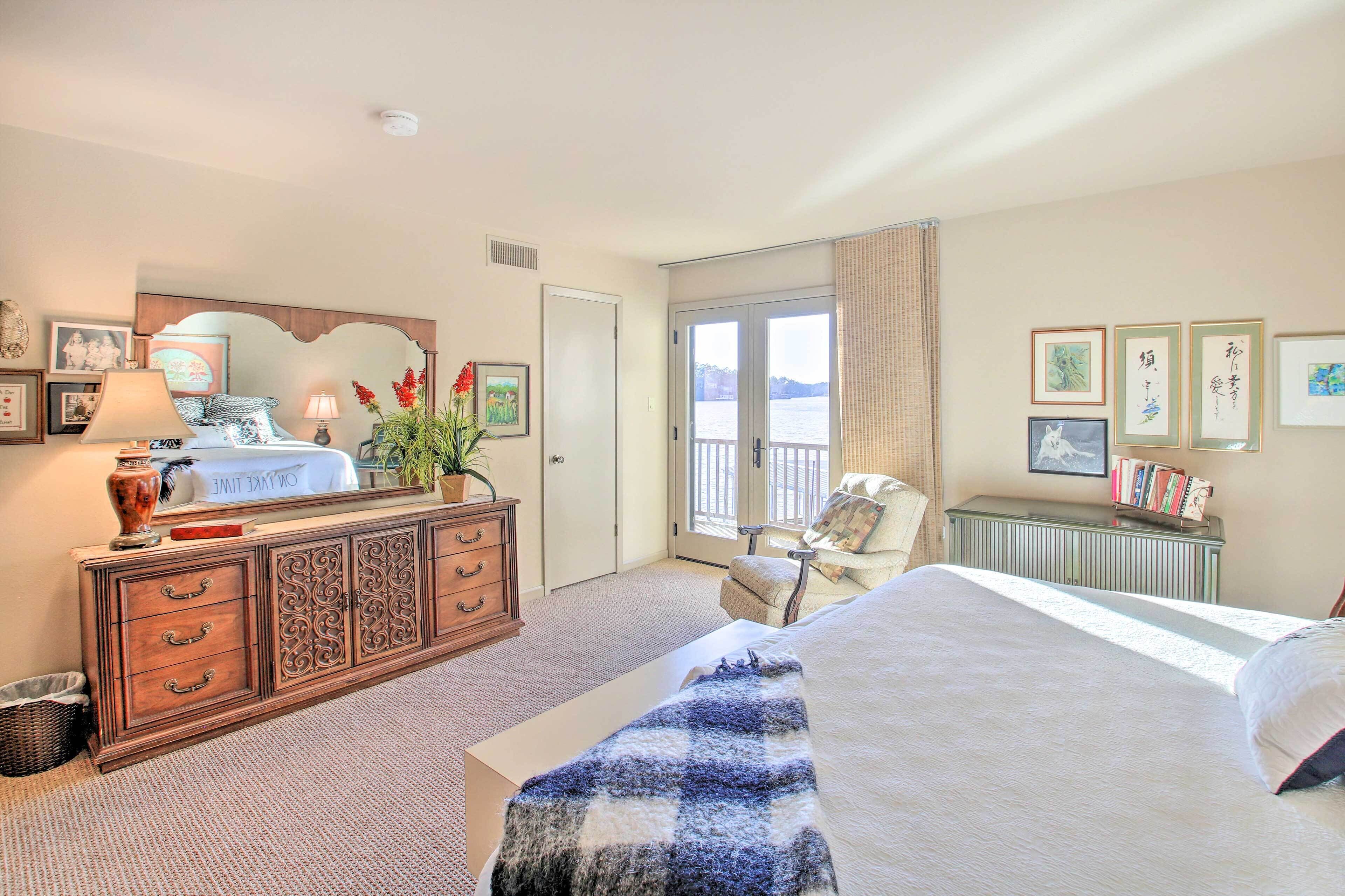 Une chambre d’hôtel équipée d’un lit, d’une commode, d’une chaise et offrant une vue sur l’extérieur grâce à une grande fenêtre.