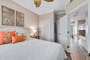 Cozy retreat with a large bed, wall art, and a door to an adjacent room.