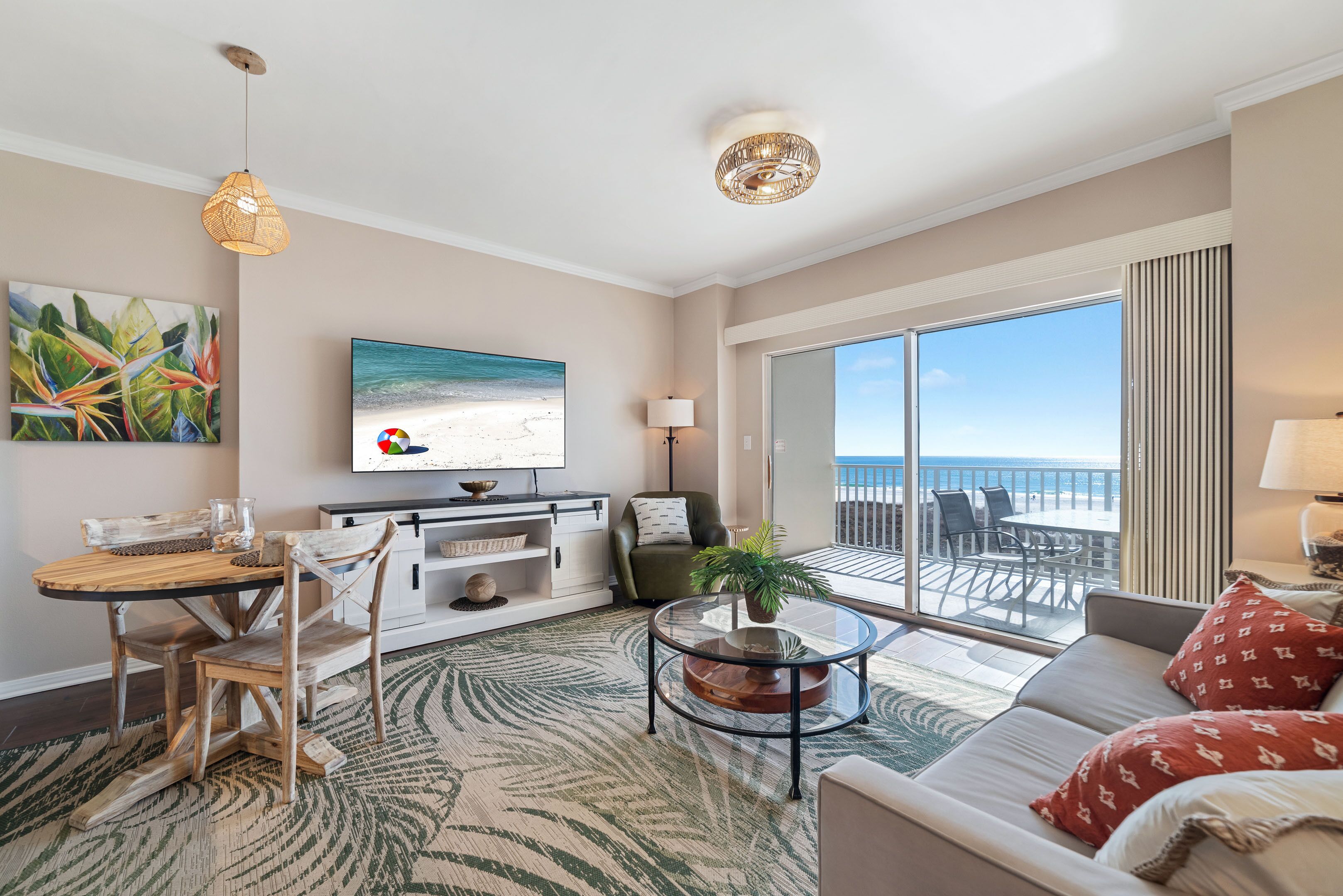 Ein Wohnzimmer mit Blick auf den Strand, einem Essbereich und einem Balkon mit Meerblick.