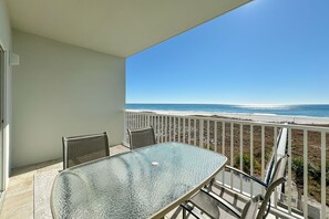 A balcony with a glass table and chairs, overlooking a beach. - Tidewater 304-Family friendly complex to enjoy the Beach! (Orange Beach)