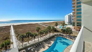 Un complexe hôtelier doté d’une piscine, offrant une vue sur la plage et comprenant une promenade en bord de mer.