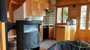 Una cucina accogliente con mobili in legno, un piano cottura nero e una finestra vista verde.