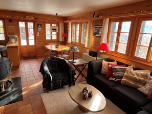 A cozy cabin interior with a dining area, a sofa, and a coffee table.