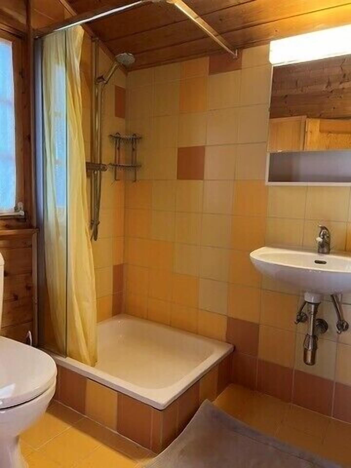 Ein Badezimmer mit Dusche, Toilette und Waschbecken.