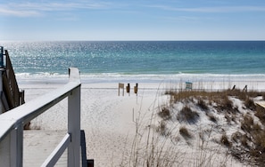 A beach with a wooden boardwalk, sandy beach, and ocean view.