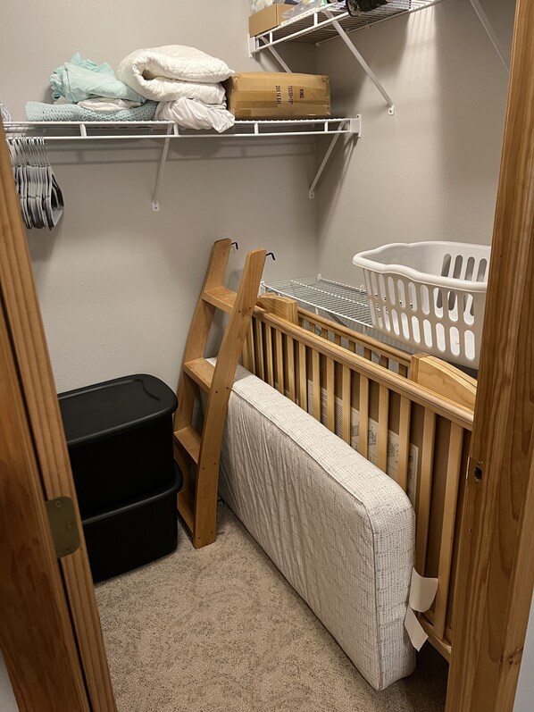 A baby room with a crib, changing table, and storage shelves. - Cozy cabin with beautiful, wooded views. 5 minutes to downtown (Balsam Lake)