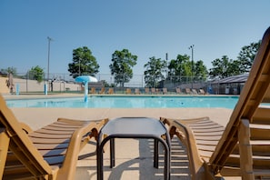 Un área de piscina con sillones de descanso y un tobogán de agua.