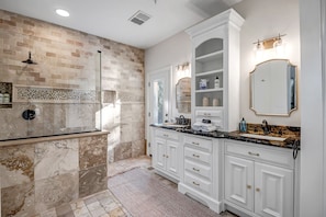 Une salle de bain avec un meuble-lavabo en marbre, deux vasques et un grand miroir.