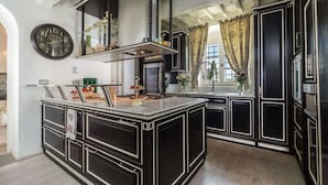 A kitchen with a central island, black cabinetry, and a large clock on the wall. - Private Villa with hot tub, sauna, A/C, private pool, WIFI, TV, patio, close to Greve In Chianti (Tavarnelle Val Di Pesa)