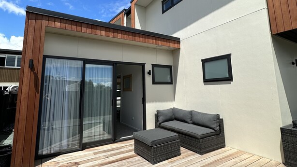 A modern house with a patio, a sliding glass door, and a built-in sofa. - Little Break Tahunanui - 5 minutes from beach (Nelson)