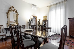 Comedor con mesa de madera, sillas, un espejo grande y decorativo, y un aparador.