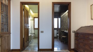 Un couloir avec une armoire en bois, un tapis à motifs et une commode en bois.