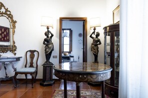 Un comedor con una mesa redonda, dos sillas, una lámpara decorativa y un espejo.