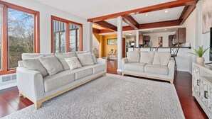 A spacious living room with two sofas, a patterned rug, and large windows. - Beautiful Hillside Home with Incredible City Views!! Great Location and Privacy! (Pittsburgh)