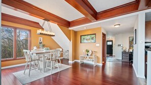 A spacious dining area with a wooden ceiling, a dining table with chairs, and a view of the outdoors through large windows. - Beautiful Hillside Home with Incredible City Views!! Great Location and Privacy! (Pittsburgh)