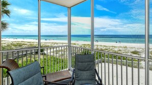 Ein Balkon mit Blick auf Strand und Meer.