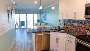 Una cocina moderna con armarios blancos, electrodomésticos de acero inoxidable y un salpicadero de azulejos.