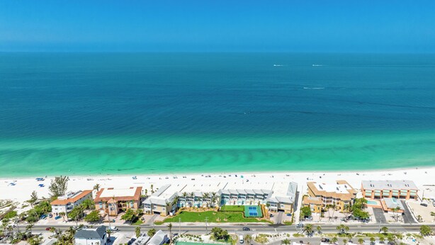 A coastal hotel with a beach view, multiple buildings, and a clear blue ocean. - Welcome to paradise! Direct beach access, summer and fall dates available!! (Bradenton Beach)