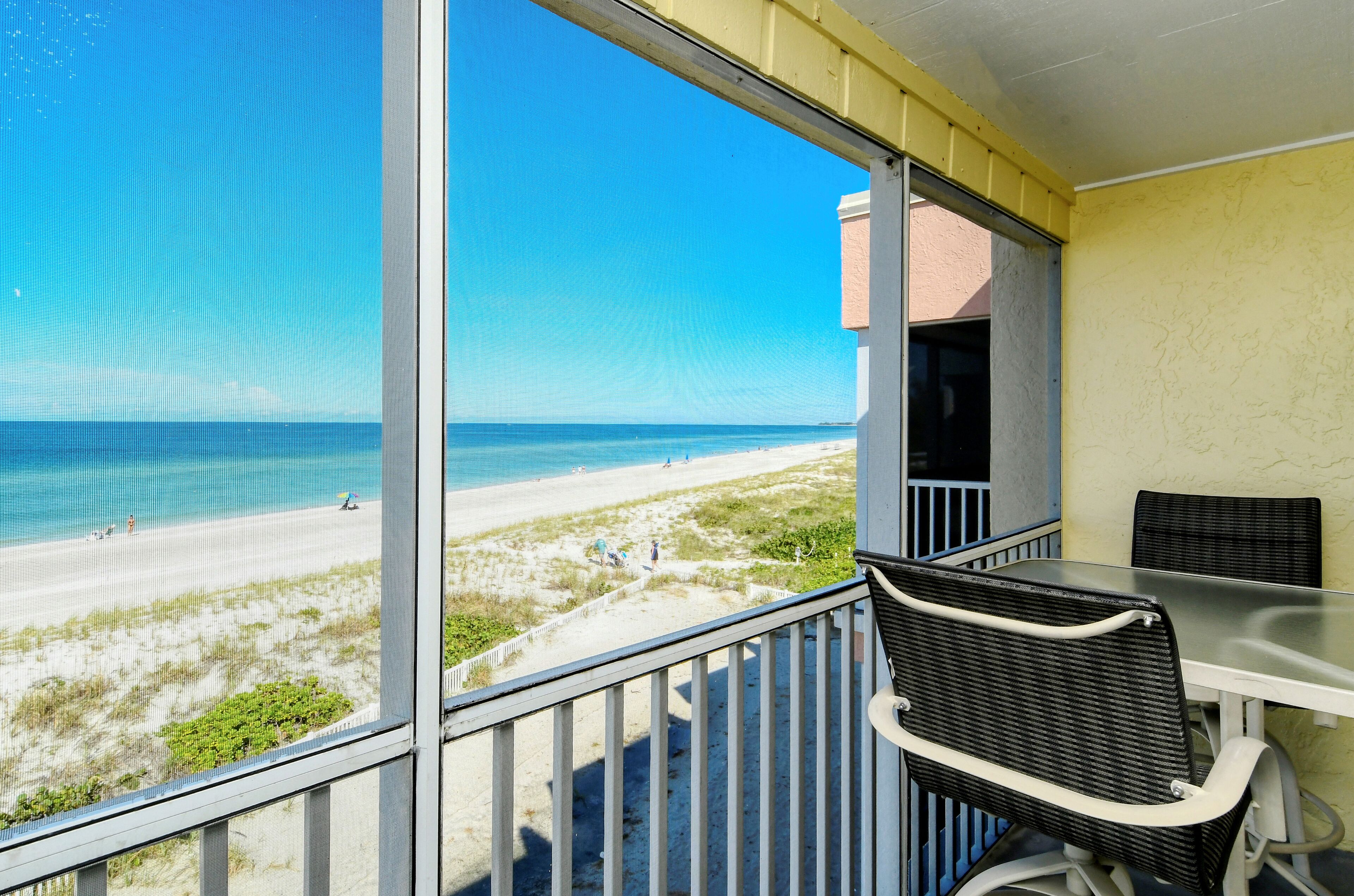 Un balcon avec vue sur la plage et l’océan.
