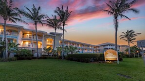 A hotel with multiple balconies, palm trees, and a sign reading "La Costa 1800". - Peak a boo Gulf of Mexico balcony views! Direct beach access! Summer and fall dates available! (Bradenton Beach)