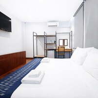 Une chambre d’hôtel équipée d’un lit, d’un bureau, d’une chaise, d’une télévision et d’un appareil de climatisation.