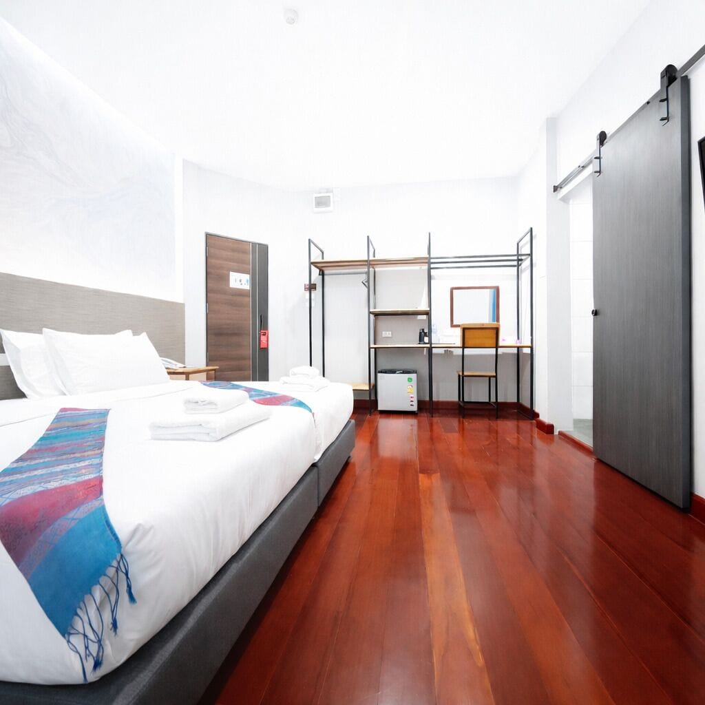 Una habitación de hotel con cama, escritorio y armario.