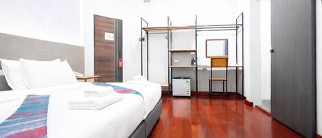 Una habitación de hotel con cama, escritorio y armario.