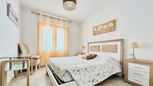 A bedroom with a bed, bedside tables, a desk, and a chair. - 2ND LINE OF THE BEACH AND THE PROMENADE OF ROSES (Roses)