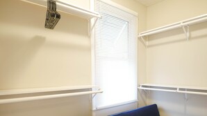Une petite pièce lumineuse, avec un lit simple, une fenêtre équipée de stores et un radiateur blanc.
